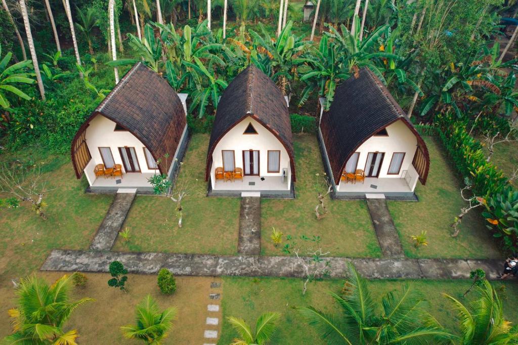 een luchtzicht van drie huizen in een bos bij The Dulu Penida Cottage in Nusa Penida