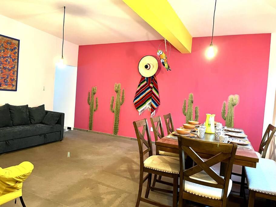 comedor con mesa y pared rosa en Apartment in the touristic heart of Mexico City, en Ciudad de México