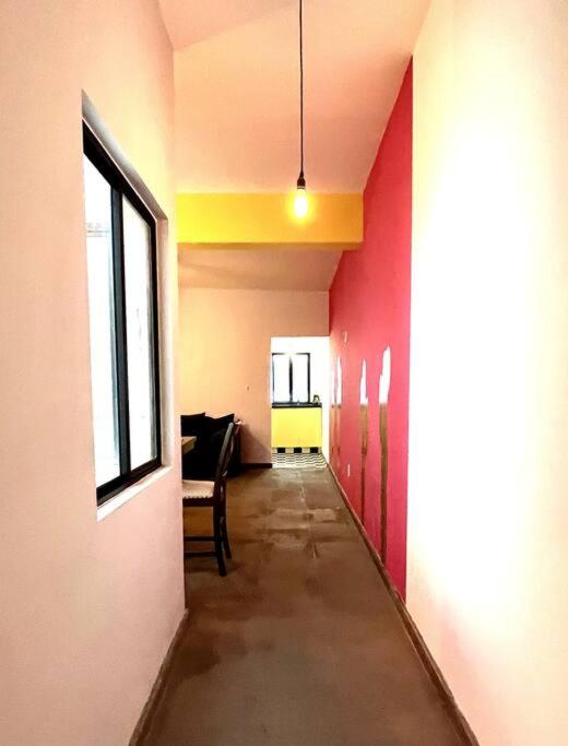 a hallway of an empty room with red and yellow walls at Apartment in the touristic heart of Mexico City in Mexico City