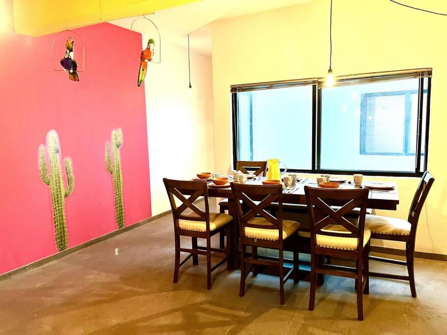 a dining room with a table and chairs and a pink wall at Apartment in the touristic heart of Mexico City in Mexico City