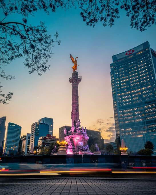 a statue in the middle of a city at night at Apartment in the touristic heart of Mexico City in Mexico City