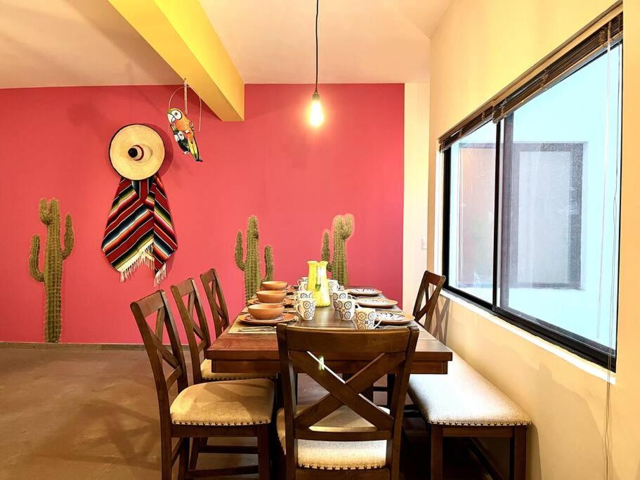a dining room with a table and chairs and a red wall at Apartment in the touristic heart of Mexico City in Mexico City