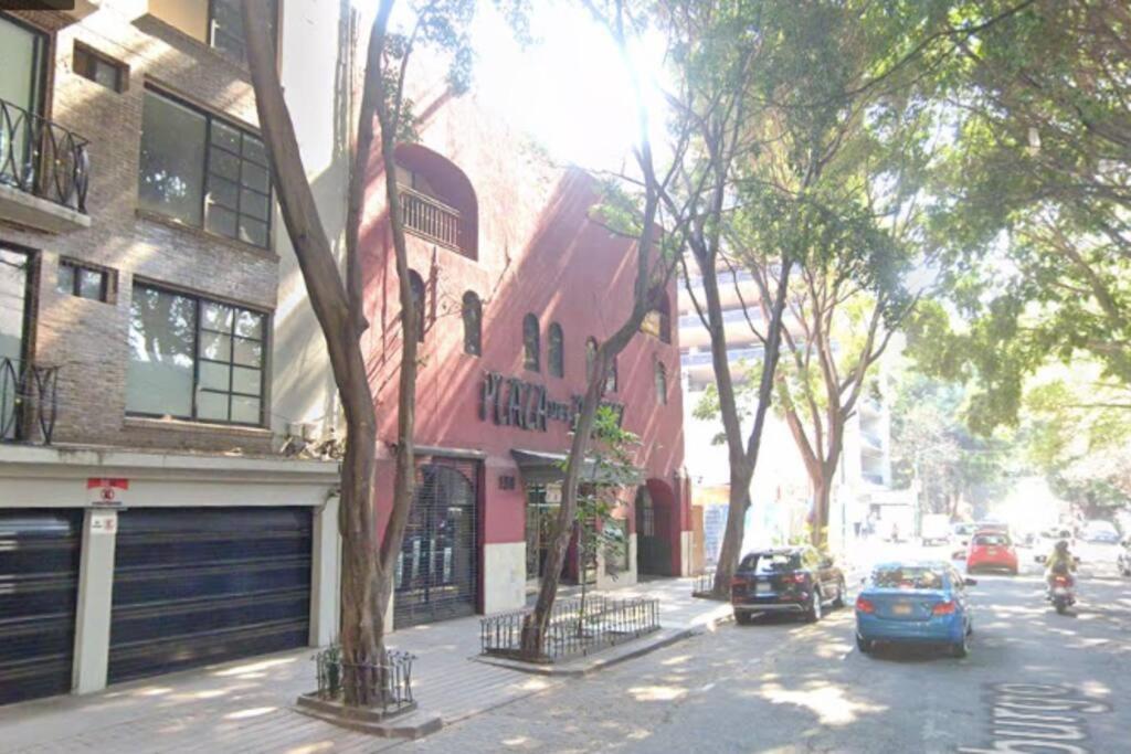 a street with cars parked in front of a building at Apartment in the touristic heart of Mexico City in Mexico City
