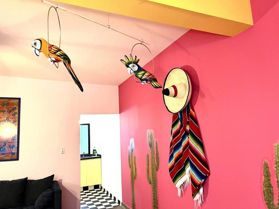 a room with a pink wall with two birds and a tie at Apartment in the touristic heart of Mexico City in Mexico City