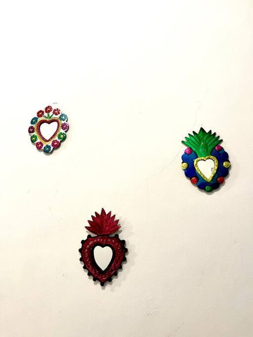 three embroideredidered hearts on a white wall at Apartment in the touristic heart of Mexico City in Mexico City