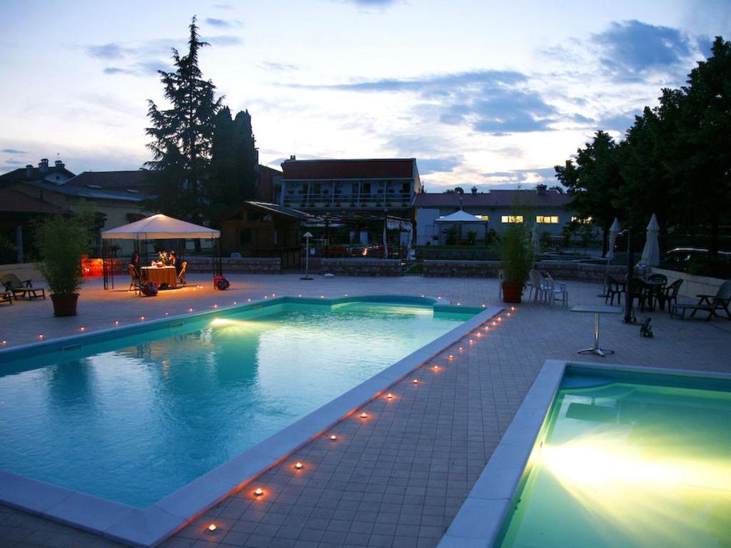 a large swimming pool with lights in a courtyard at Gelindo Dei Magredi in Vivaro