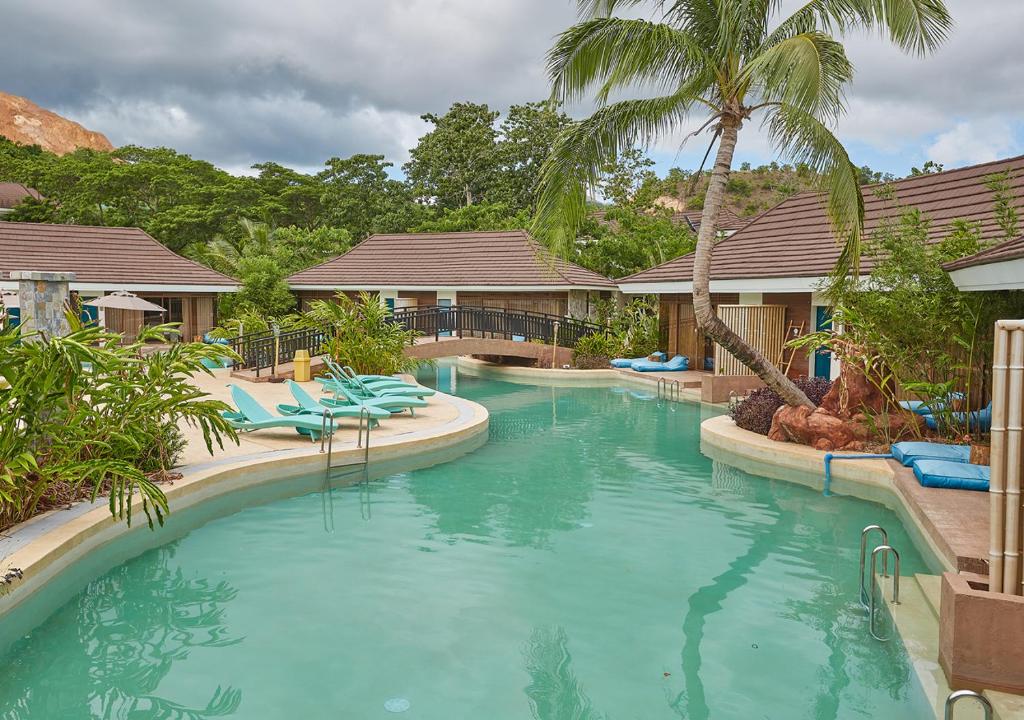 a swimming pool with blue water in a resort at Tag Resort in Coron