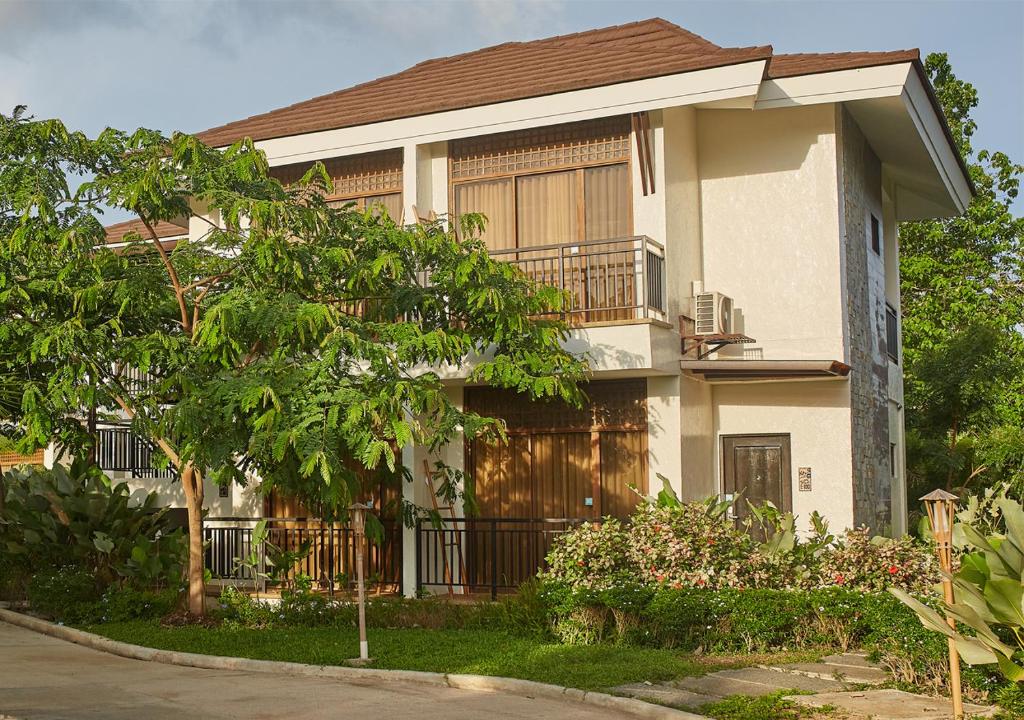 a house with a fence and a tree at Tag Resort in Coron