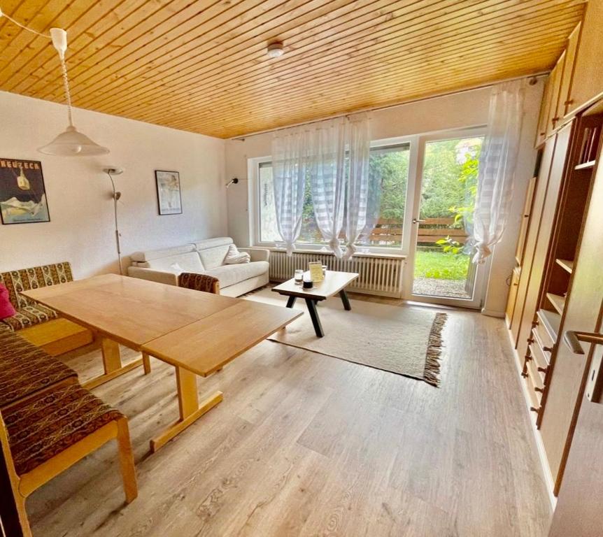 ein Wohnzimmer mit einem Tisch und einem Sofa in der Unterkunft Cozy Condo, Ski in and Out in Todtnau