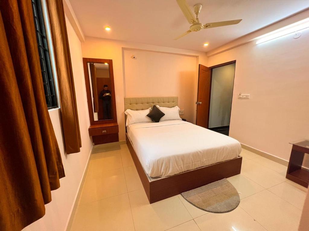 a bedroom with a bed and a ceiling fan at Hotel InTourist by Agira Hotel in Bangalore