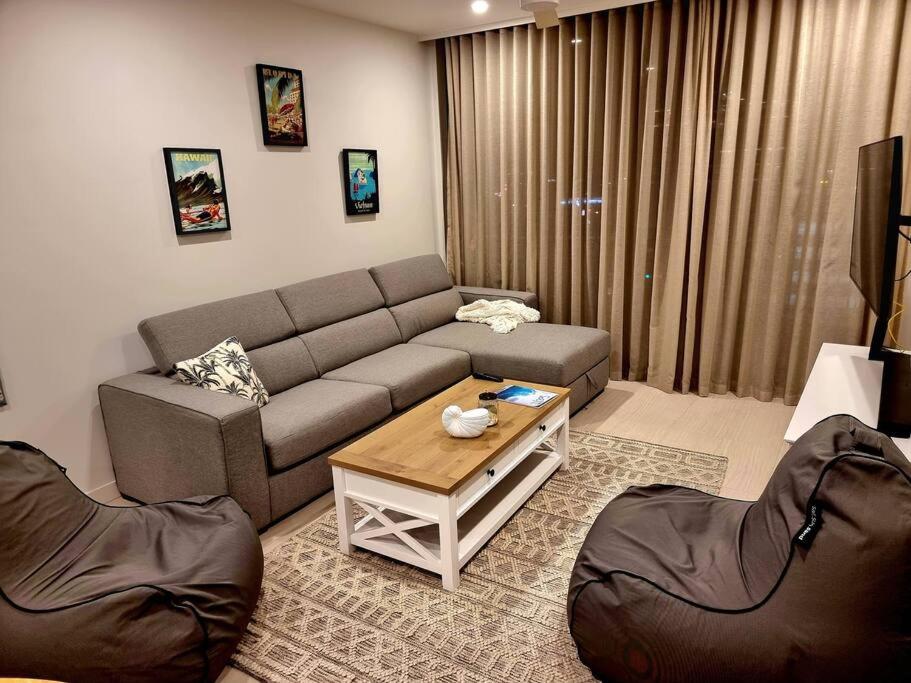 Maroochy City Lights@Thecosmopolitan Unit 20802 في ماروتشيدور: غرفة معيشة مع أريكة وطاولة قهوة