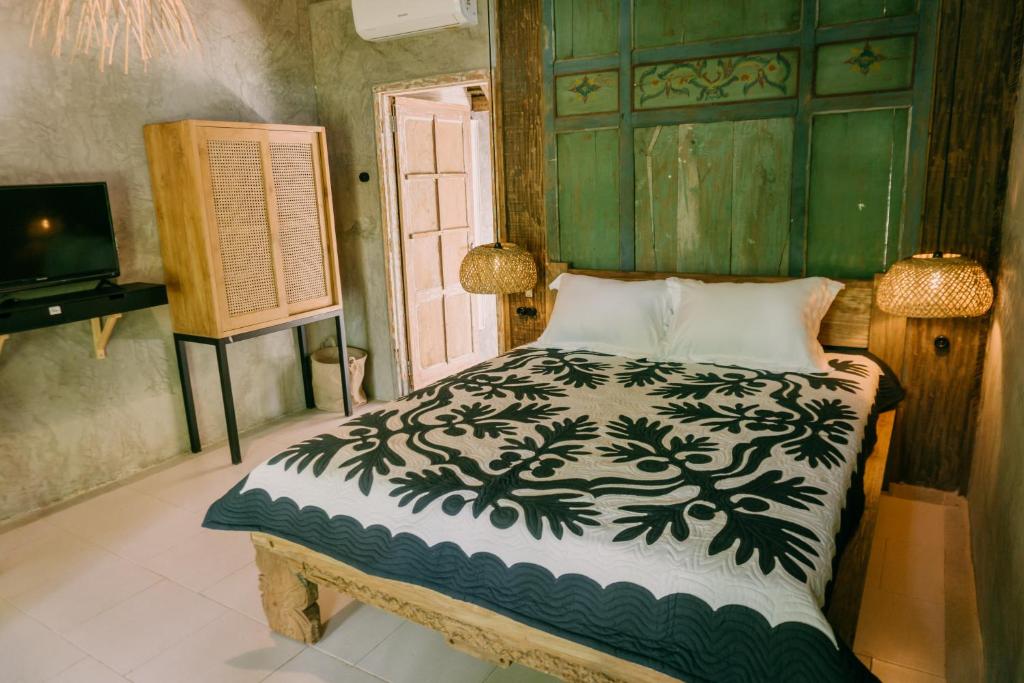 um quarto com uma cama com um edredão preto e branco em East room at Semadi Living em Darmasaba