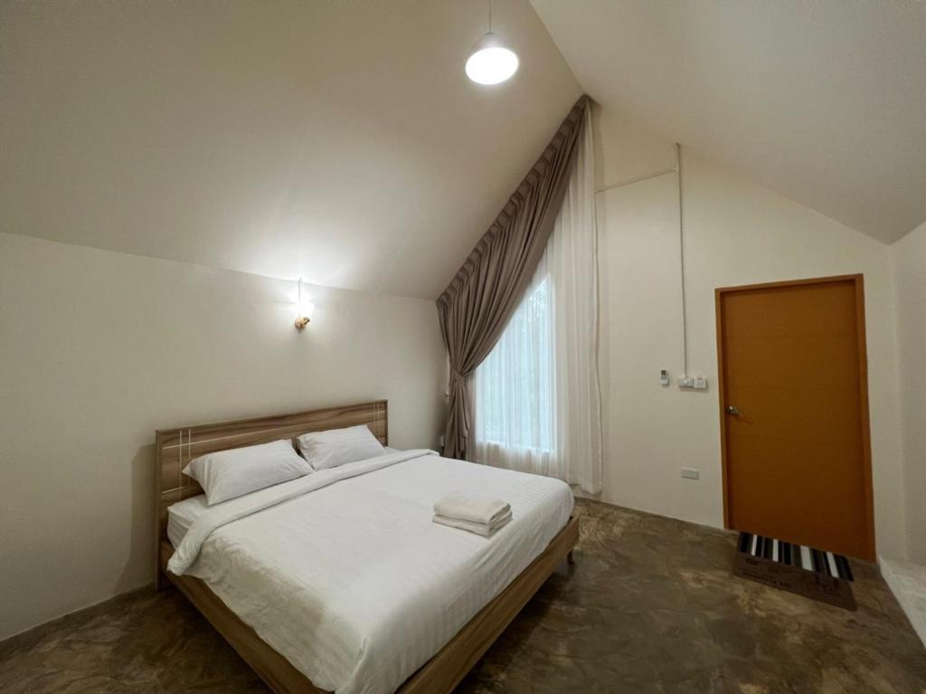 a bedroom with a large white bed and a window at Promma Farm Resort in Ban Tat Ton (1)