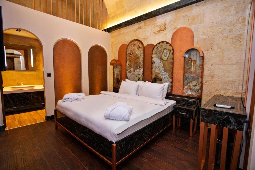 a bedroom with a bed with towels on it at Bayazhan Hotel ve Restaurant in Gaziantep