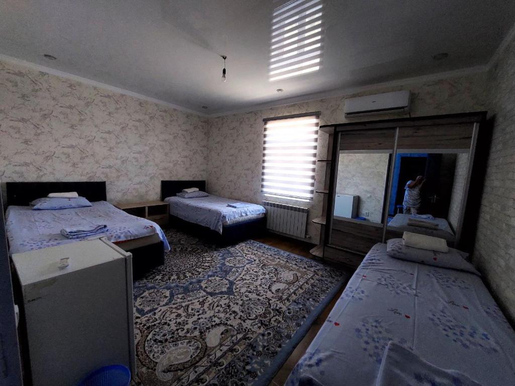 a room with two beds and a mirror in it at Green house in Nukus