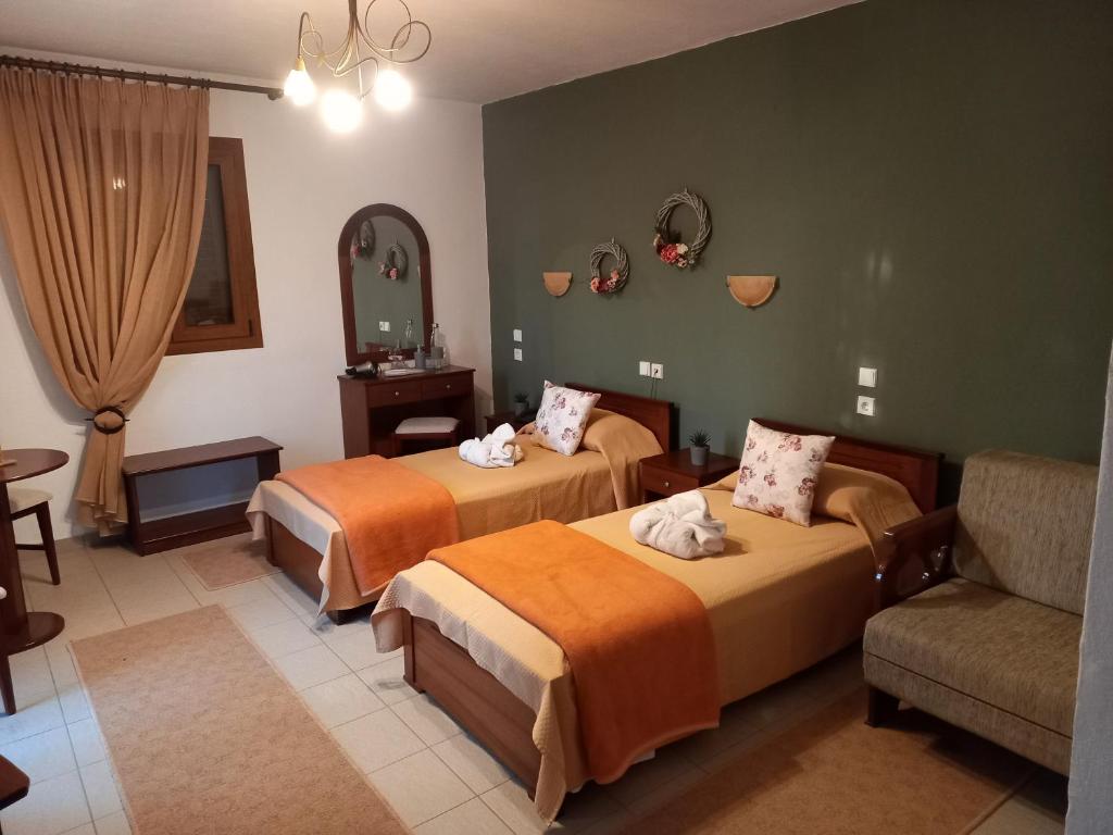 a hotel room with two beds and a couch at Hotel Metoxi in Spiliá