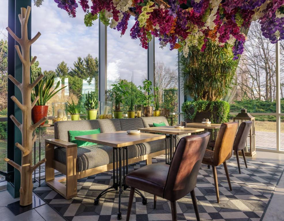 um restaurante com mesas, cadeiras e flores em Holiday Inn Hotel Brussels Airport, an IHG Hotel em Diegem