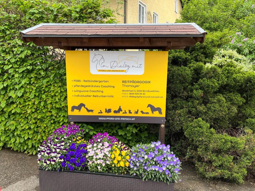 Ein Schild vor einem Blumenstrauß in der Unterkunft Pferdehof Thomayer in Strasswalchen