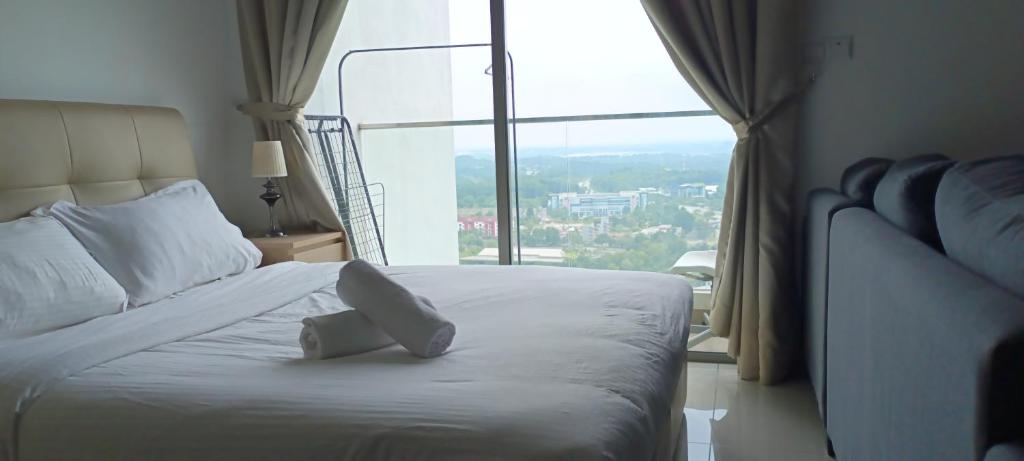 a bedroom with a white bed with a large window at Cyberjaya cybersqure peace home in Cyberjaya