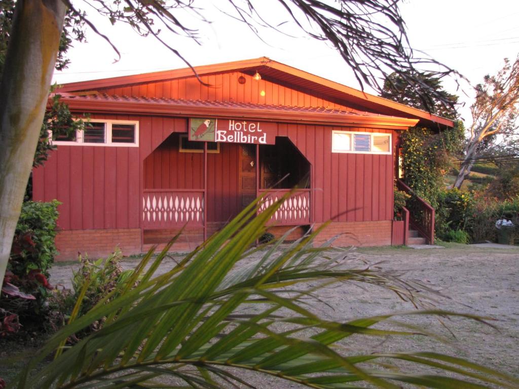 ein rotes Gebäude mit einem Schild davor in der Unterkunft Hotel Bell Bird in Monteverde Costa Rica