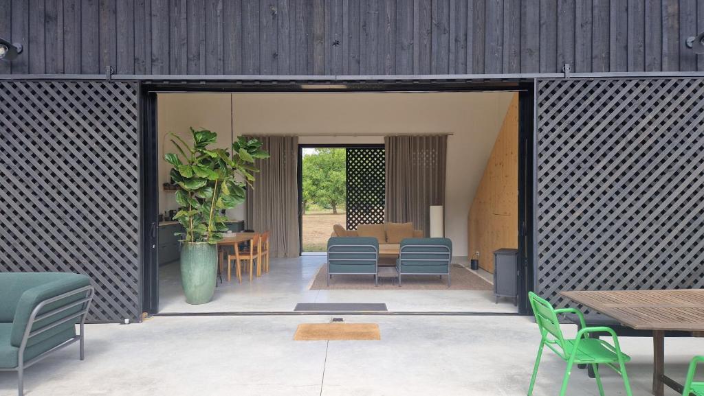 a patio with chairs and a table and a plant at La Maison dans l'Airial, maison d'architecte en pleine nature, PISCINE in Onesse-et-Laharie