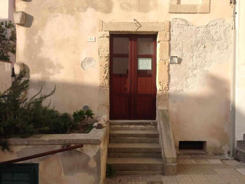 オートラントにあるAppartamento Gelso Biancoの階段付きの建物の赤い扉