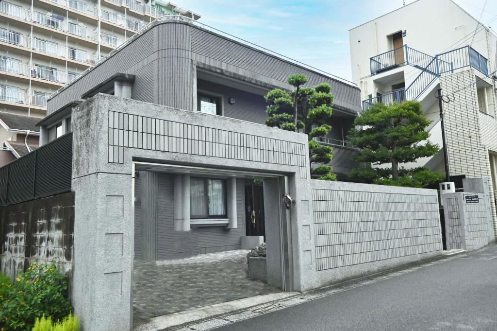 una casa de ladrillo con una valla delante de un edificio en Private Beppu Tanoyu Onsen, en Beppu