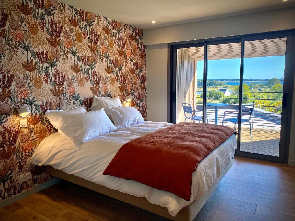 um quarto com uma cama e vista para uma varanda em La Bellevue Bistrot et Chambres d'Hotes em Séné