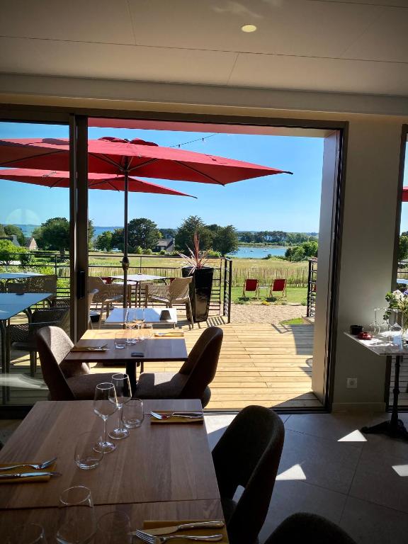 restauracja ze stołami i krzesłami z widokiem na patio w obiekcie La Bellevue Bistrot et Chambres d'Hotes w mieście Séné