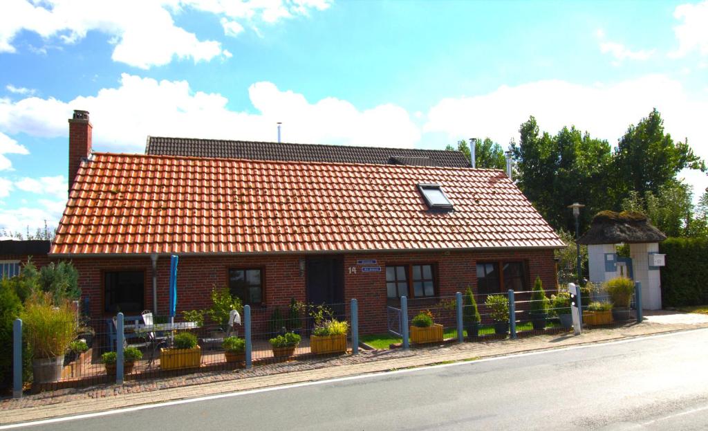 una pequeña casa de ladrillo con techo de baldosa naranja en "Alte Schmiede", en Nordenham
