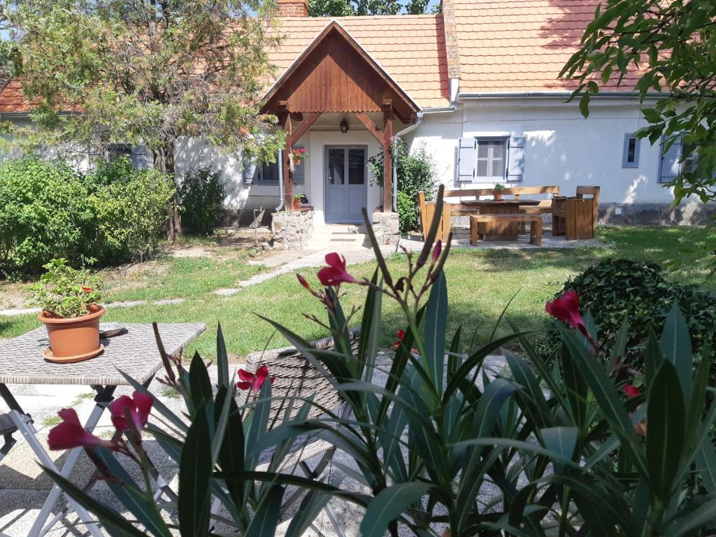 ein Haus mit einem Tisch und Blumen im Hof in der Unterkunft A la maison - épp mint otthon in Szentbékkálla