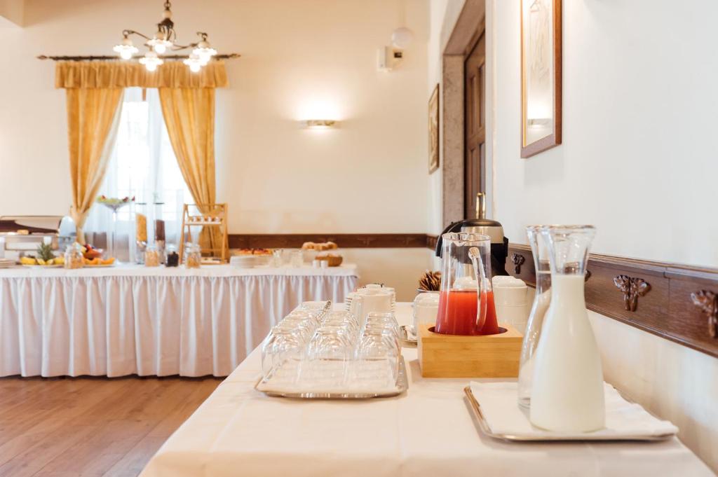 a table with glasses and bottles and a table with a buffet at Hotel & Restaurant Pahor in Doberdò del Lago