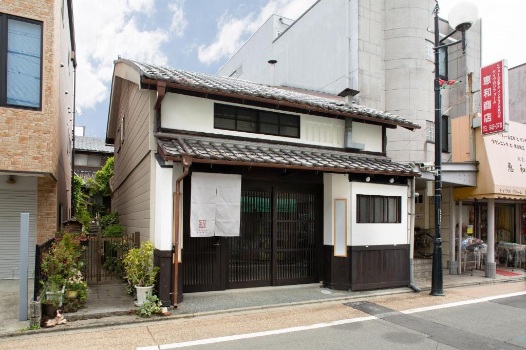 a house with a japanese gate on a street at Kanade Fushimiinari in Momoyama-chō
