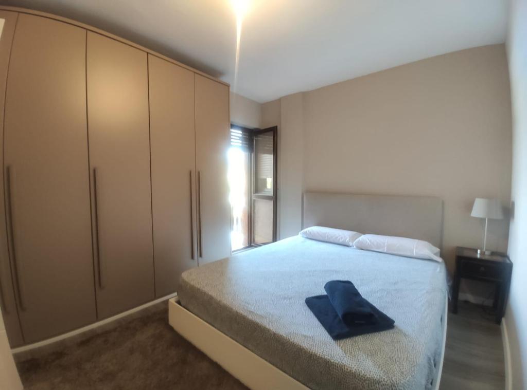 Un dormitorio con una cama con un sombrero negro. en Apartamento D´Ousseau, en Jaca