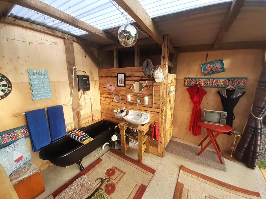 Habitación con sofá, mesa y TV. en Father Ted Retro Caravan!, en Drumaville
