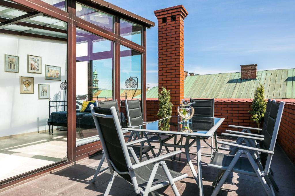 patio ze szklanym stołem i krzesłami w obiekcie 7 Koron - Exclusive Apartments w Krakowie