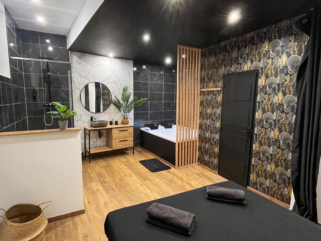 a bathroom with a tub and a sink and a mirror at Suite cocooning & spa in Béziers