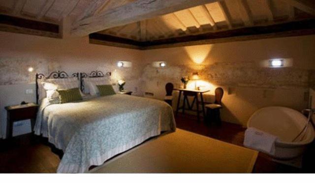 a bedroom with a large bed and a table at Antica Corte Pallavicina Relais in Polesine Parmense