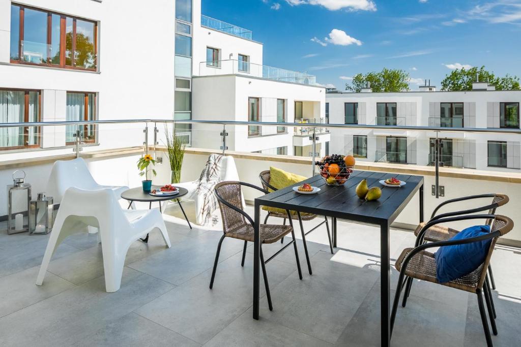 a patio with a table and chairs on a balcony at Vistula Boutique Exclusive Apartments in Krakow