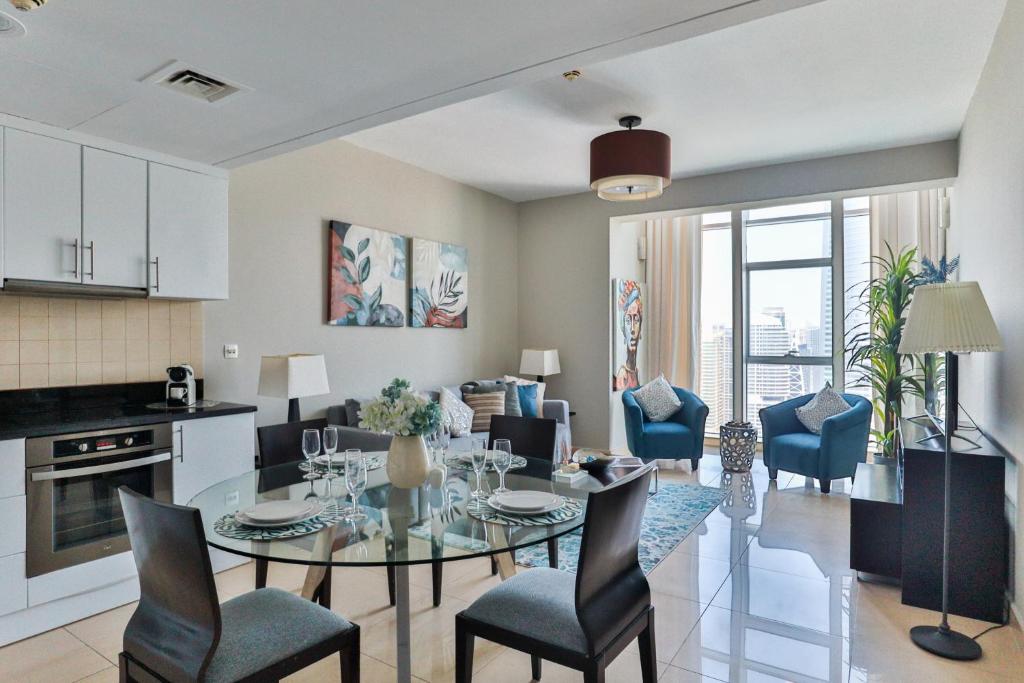 a kitchen and living room with a table and chairs at HiGuests - Fabulous Duplex With Breathtaking Lake Views in Dubai