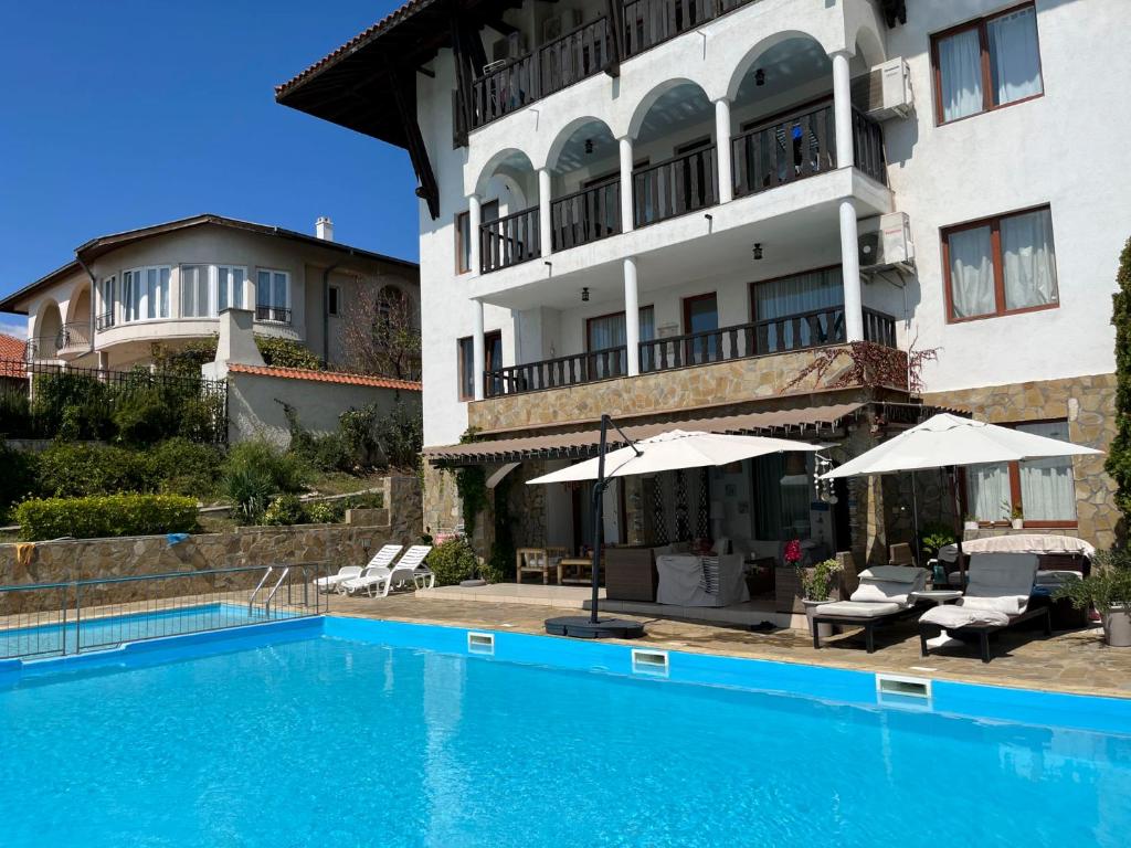 a hotel with a swimming pool in front of a building at Комплекс «ТОП» in Sveti Vlas