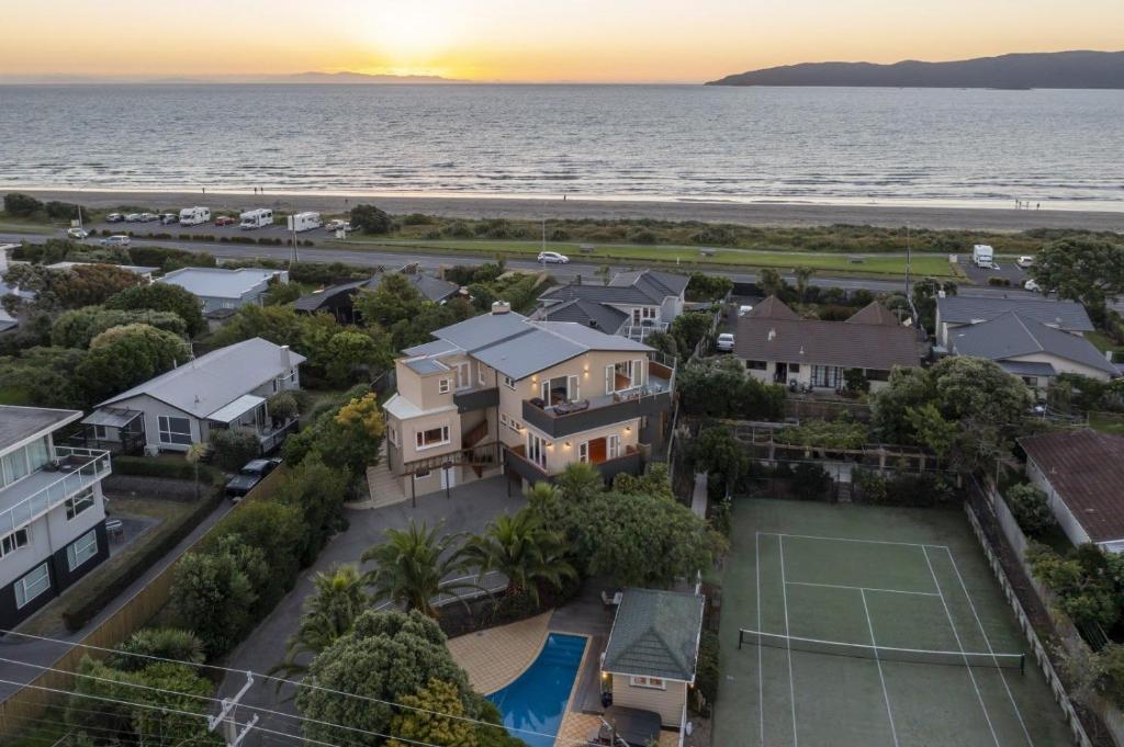 uma vista aérea de uma casa com um campo de ténis em Kapiti Getaway - Paraparaumu Beach Rental em Paraparaumu Beach