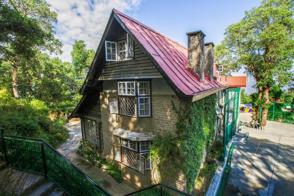 a house with ivy growing on the side of it at StayVista at Northwood Cottage with Vintage Luxury in Shimla