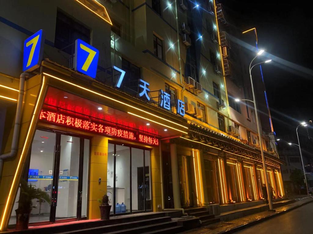 a building with a sign on the side of it at night at 7Days Inn Anqing Train Station Branch in Anqing