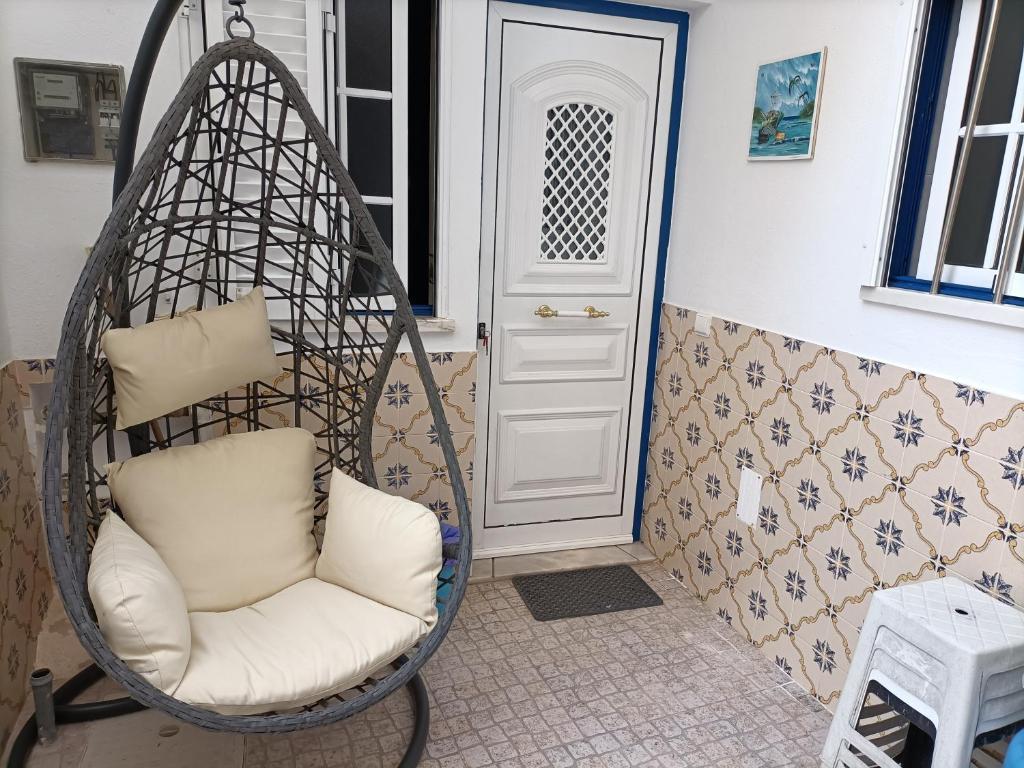 a swing chair in front of a door at Estúdio Mário Fanha in Nazaré