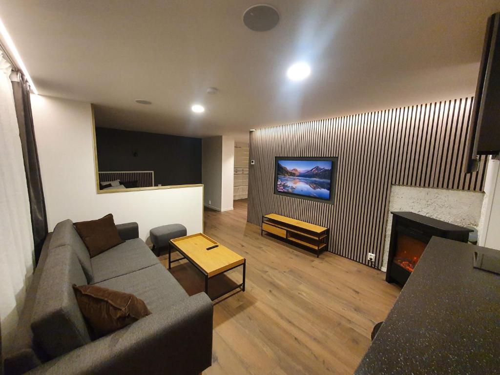 uma sala de estar com um sofá e uma lareira em Nord Hus Service AS, Nr 1 em Havøysund