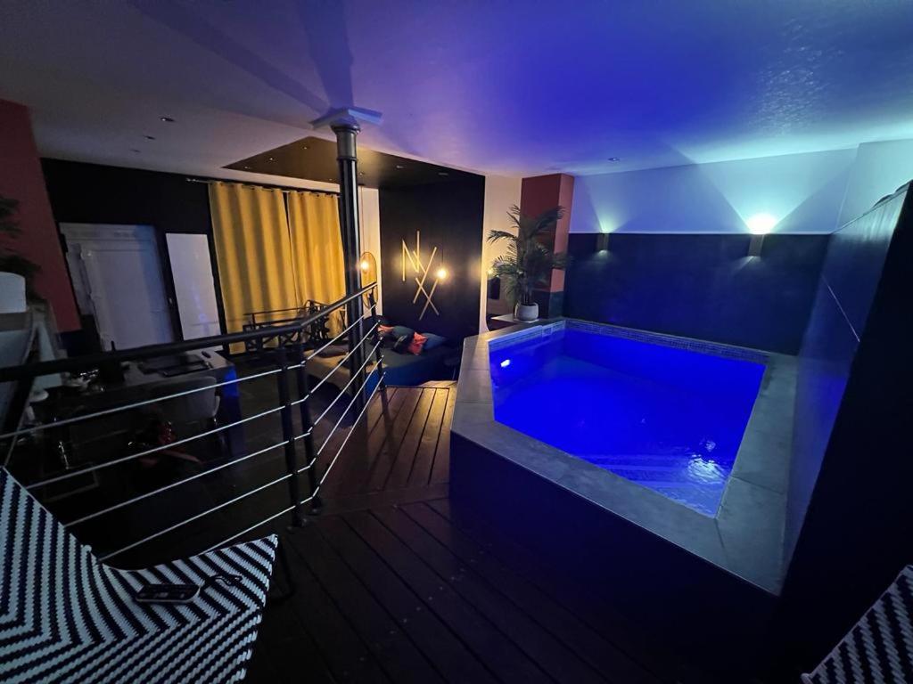 - une grande salle de bains pourvue d'une baignoire bleue dans l'établissement Nyx suite d’exception, à Dijon