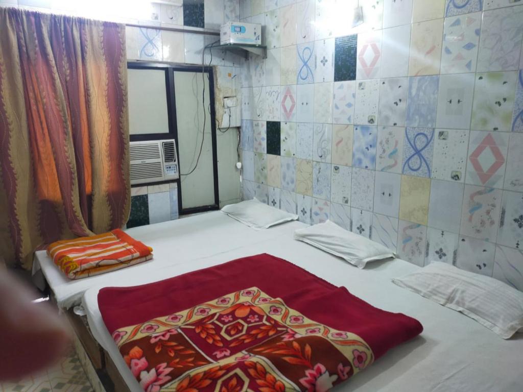 una camera con un letto con una coperta rossa sopra di Hotel Darpan By WB Inn a Jammu