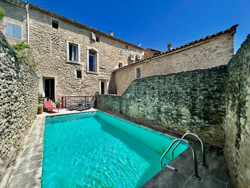 a swimming pool in the courtyard of a building at La Villa 1777 in Lagnes