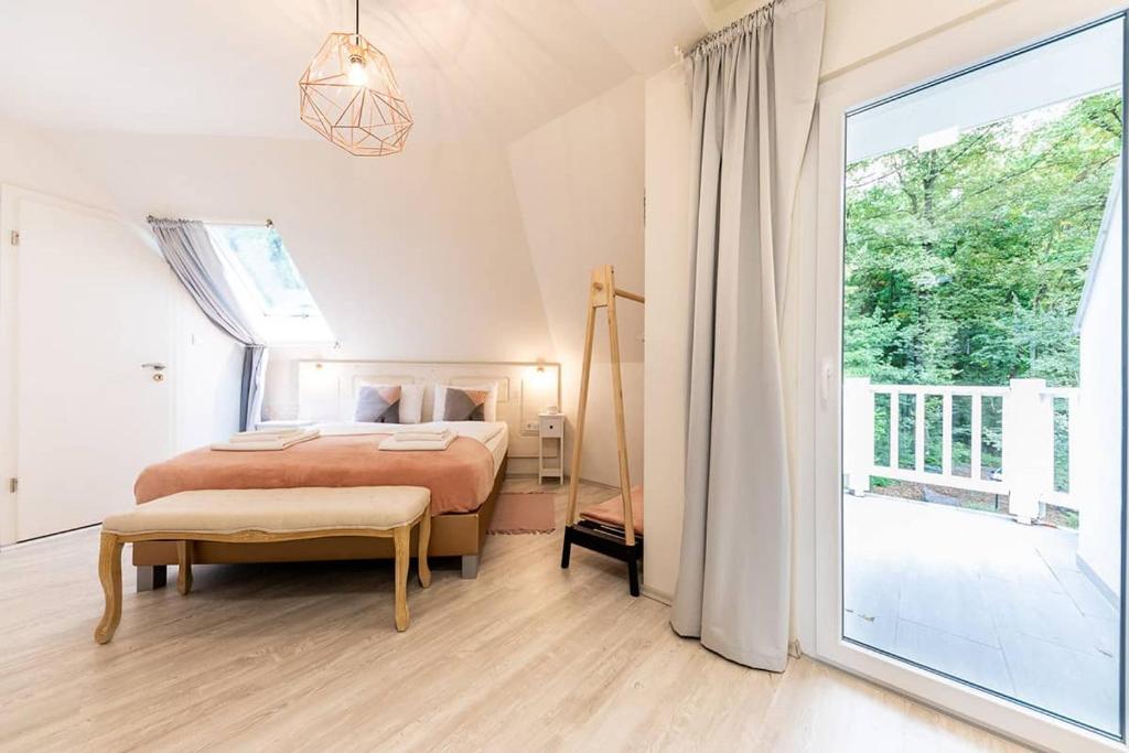 a bedroom with a bed and a large window at Magnólia in Nagykanizsa